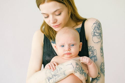 Mère Tatouée Portant Son Bébé Mignon