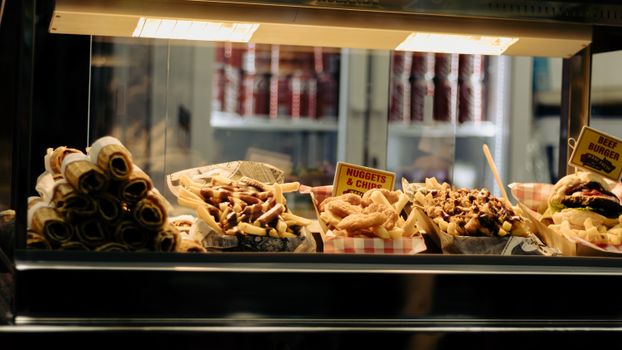 A variety of fast food items like burgers and chips displayed under warm lights in Townsville.
