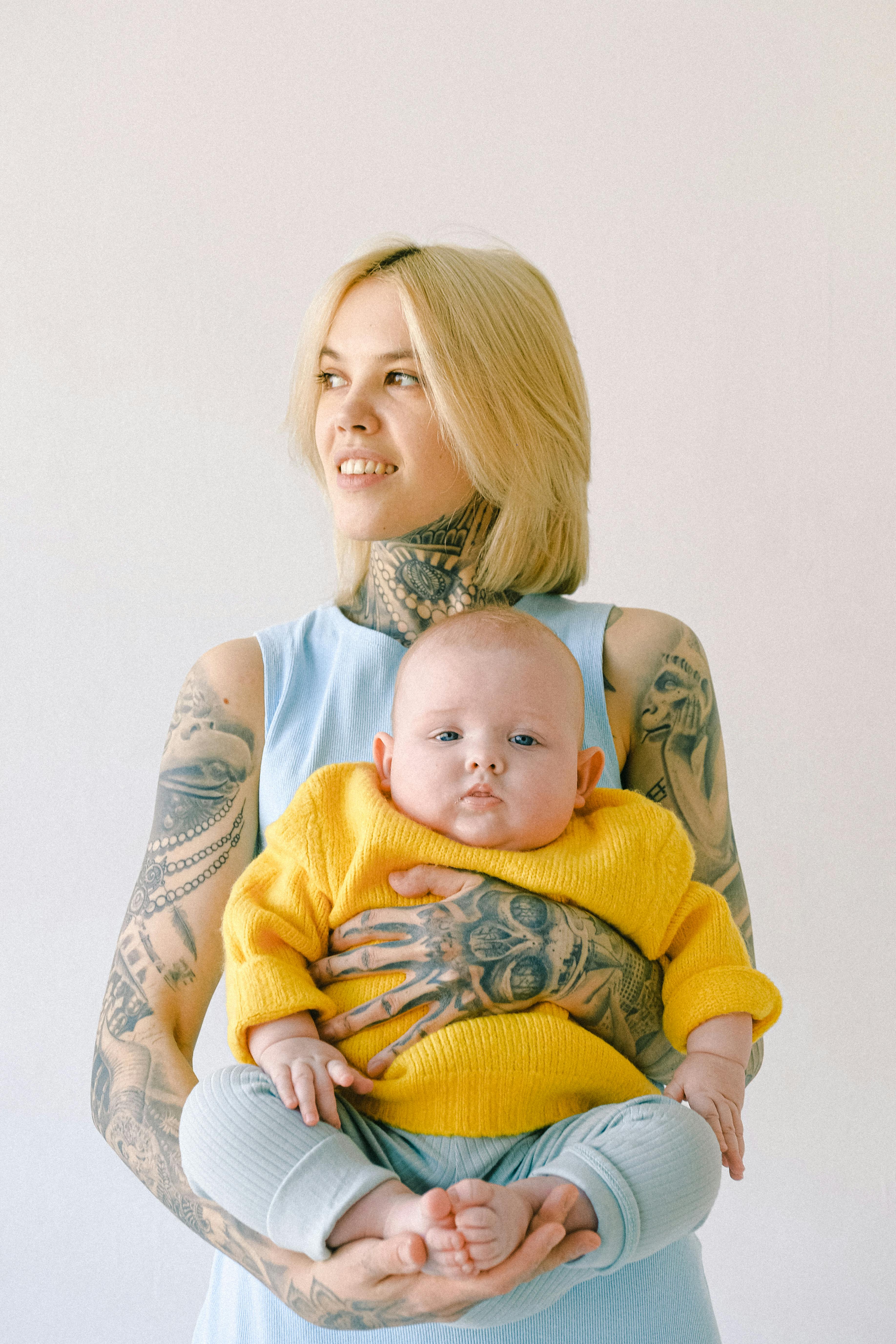 tattooed mother carrying her cute baby