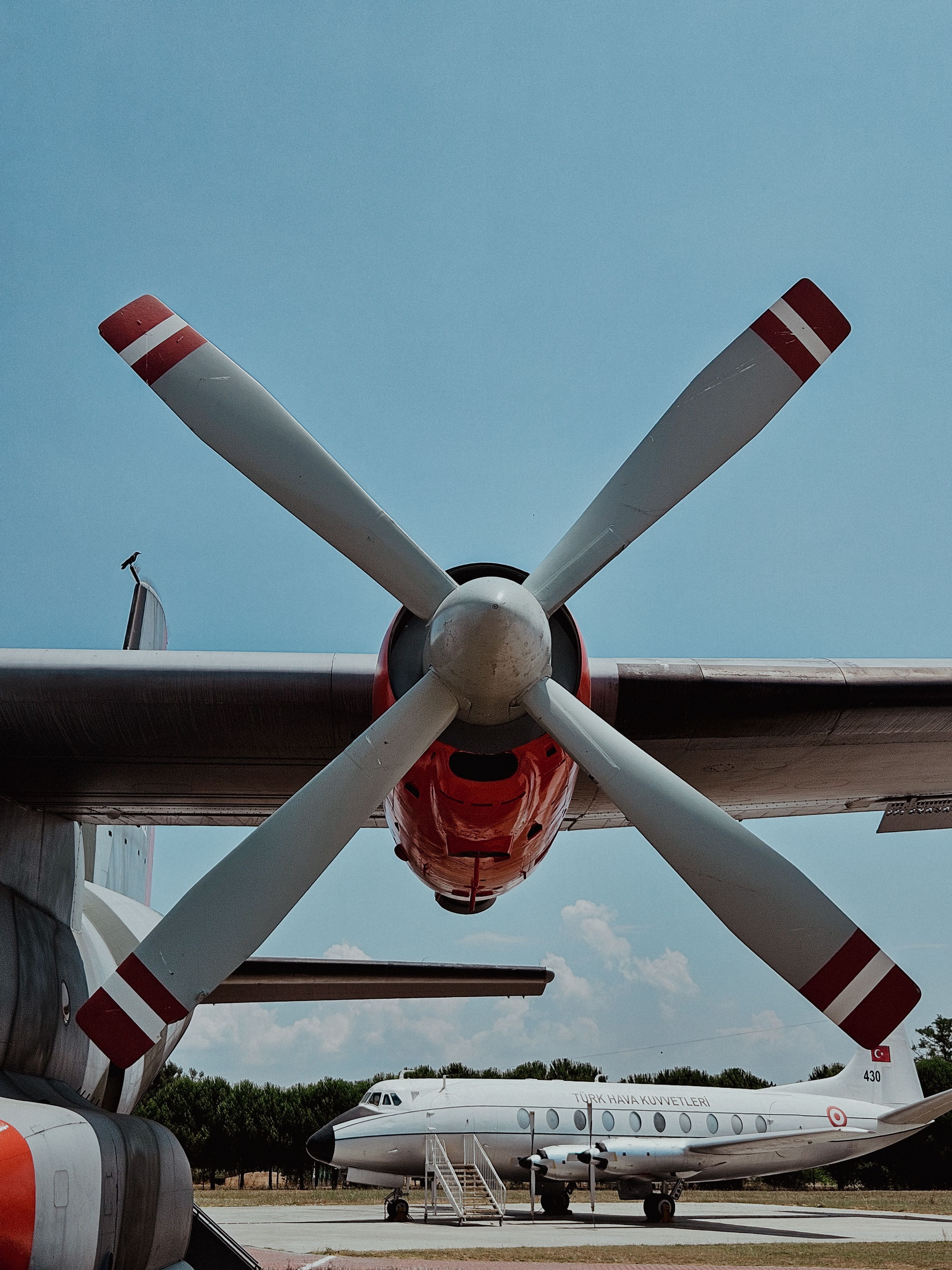 Turboprop airplane close-up with vibrant red accents at İstanbul outdoor museum on a clear day.