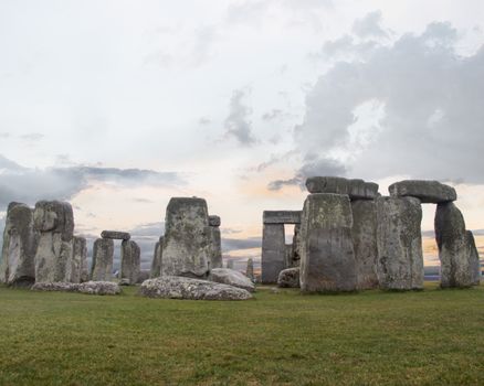 Iconic Stonehenge captured at sunset with a dramatic cloudy sky.