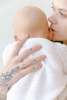 一位慈爱的母亲紧紧抱着孩子，展示她手上的纹身