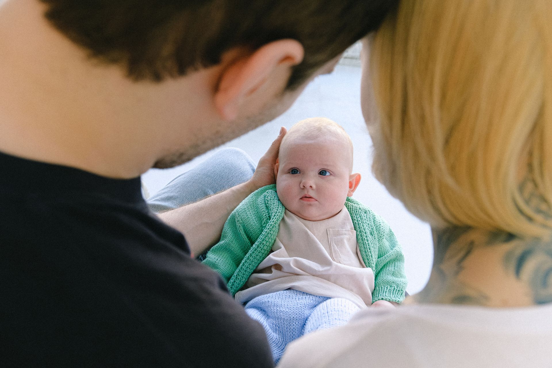 Crop parents communicating with newborn baby in arms