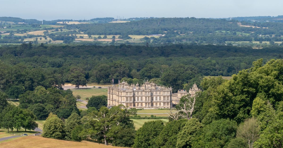 A stunning view of Longleat House surrounded by lush greenery in England's picturesque landscape.