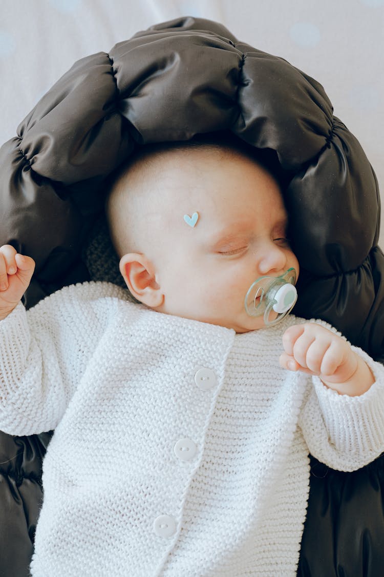 Adorable Infant Sleeping In Soft Bassinet In Bedroom