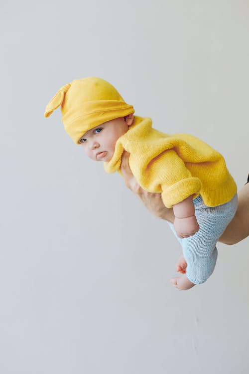 노란색 니트 모자와 노란색 스웨터에 아이