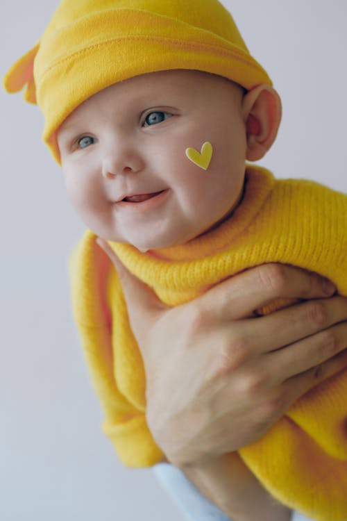黄色のニット帽と黄色のニットセーターの赤ちゃん