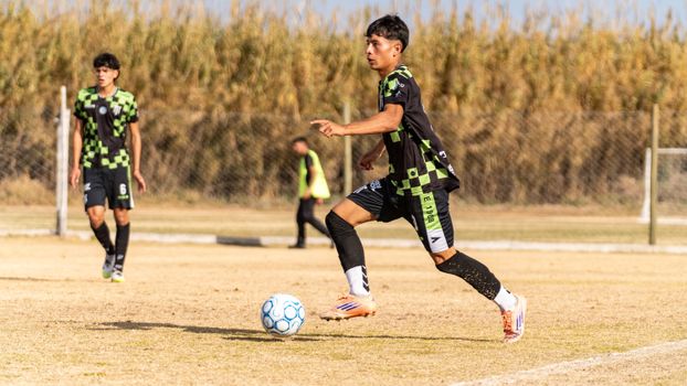 A young athlete playing soccer in a lively outdoor match.