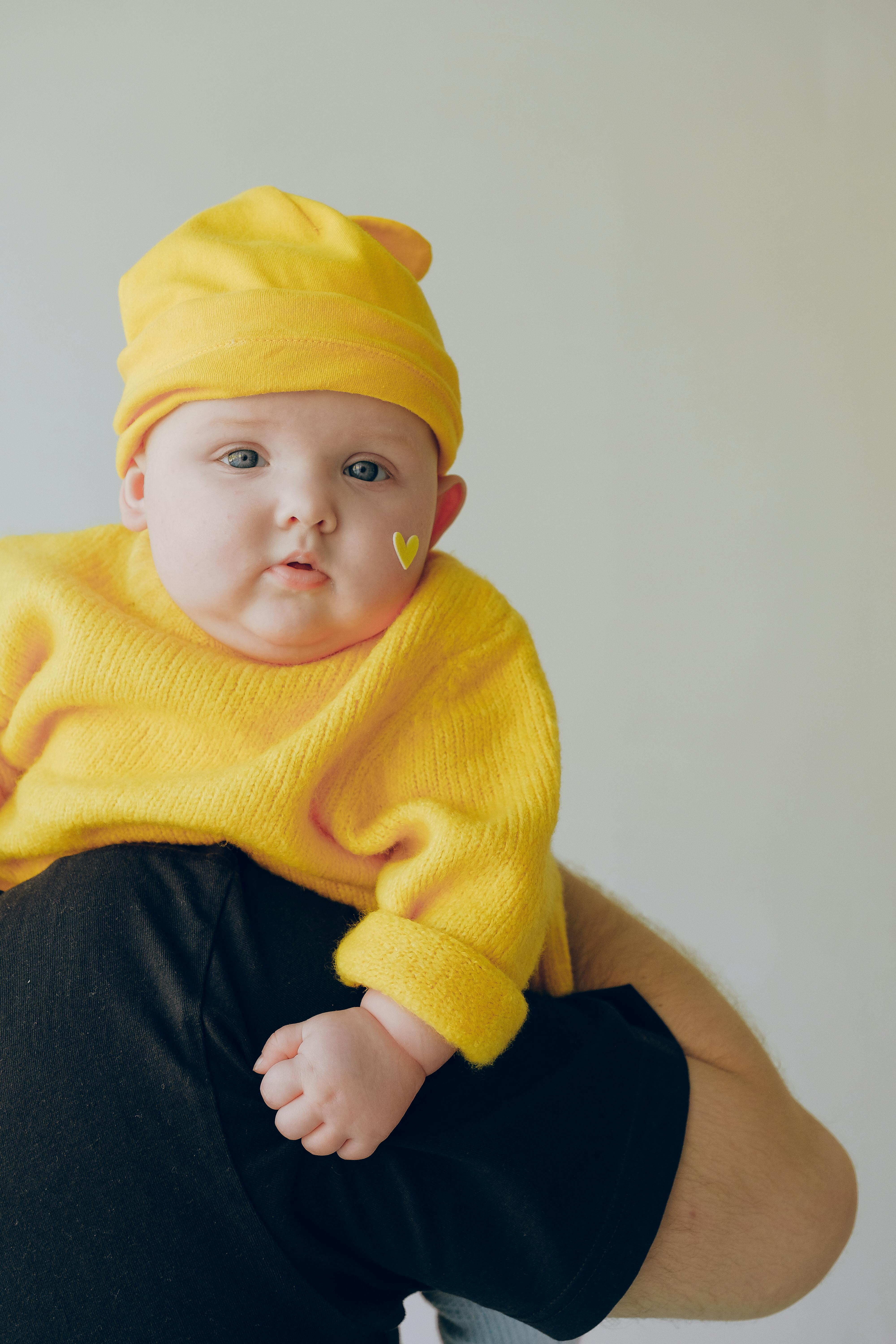 baby in yellow knit sweater and yellow knit cap