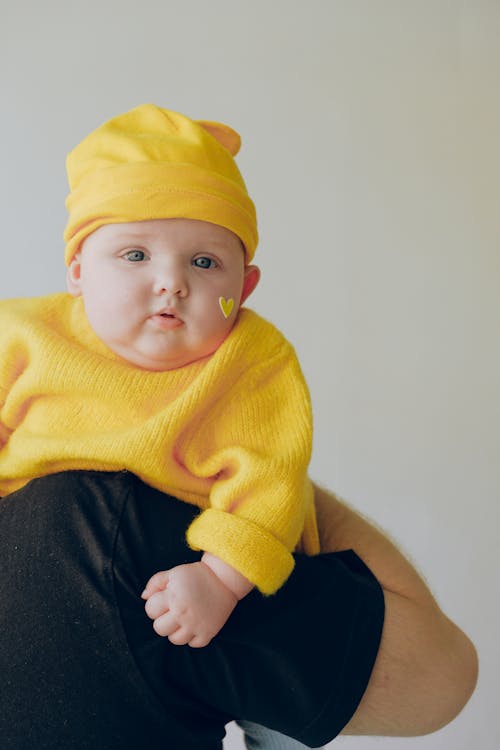 Bebé En Suéter De Punto Amarillo Y Gorro De Punto Amarillo