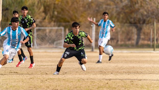Dynamic capture of youth soccer players in action during a competitive match on a sunny day.