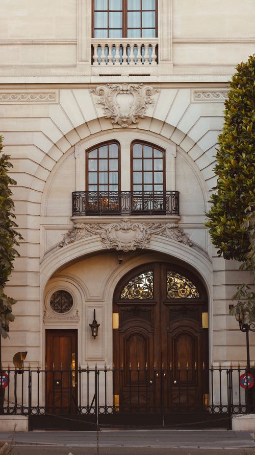Free A detailed view of an ornate Parisian building facade showcasing classic architectural design and intricate woodwork. Stock Photo