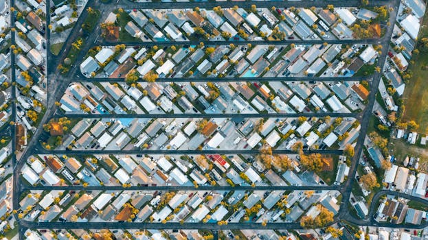 Drone view of modern buildings located in rows between roads in suburb of contemporary town on daytime