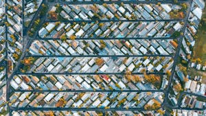 Drone view of modern buildings located in rows between roads in suburb of contemporary town on daytime