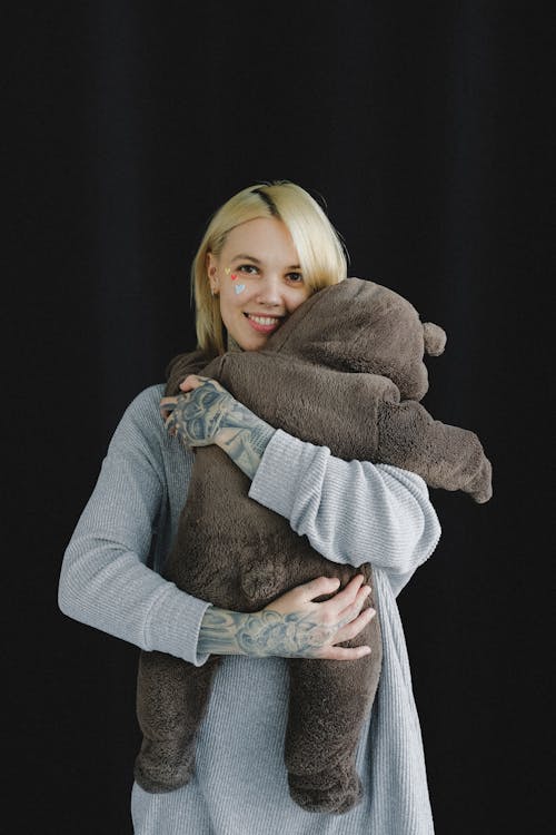 Free Happy mother hugging baby in bear costume in photo studio Stock Photo