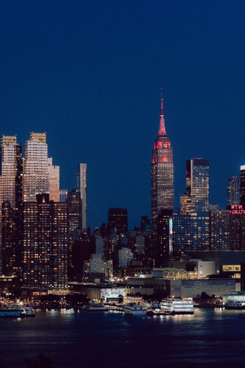 Free Stunning night view of New York City's skyline featuring the illuminated Empire State Building. Stock Photo