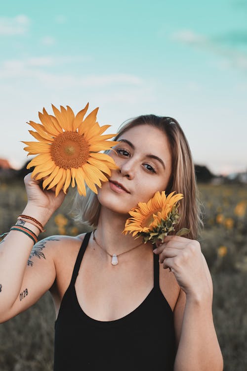 Woman in Black Tank Top Holding Sunflower
