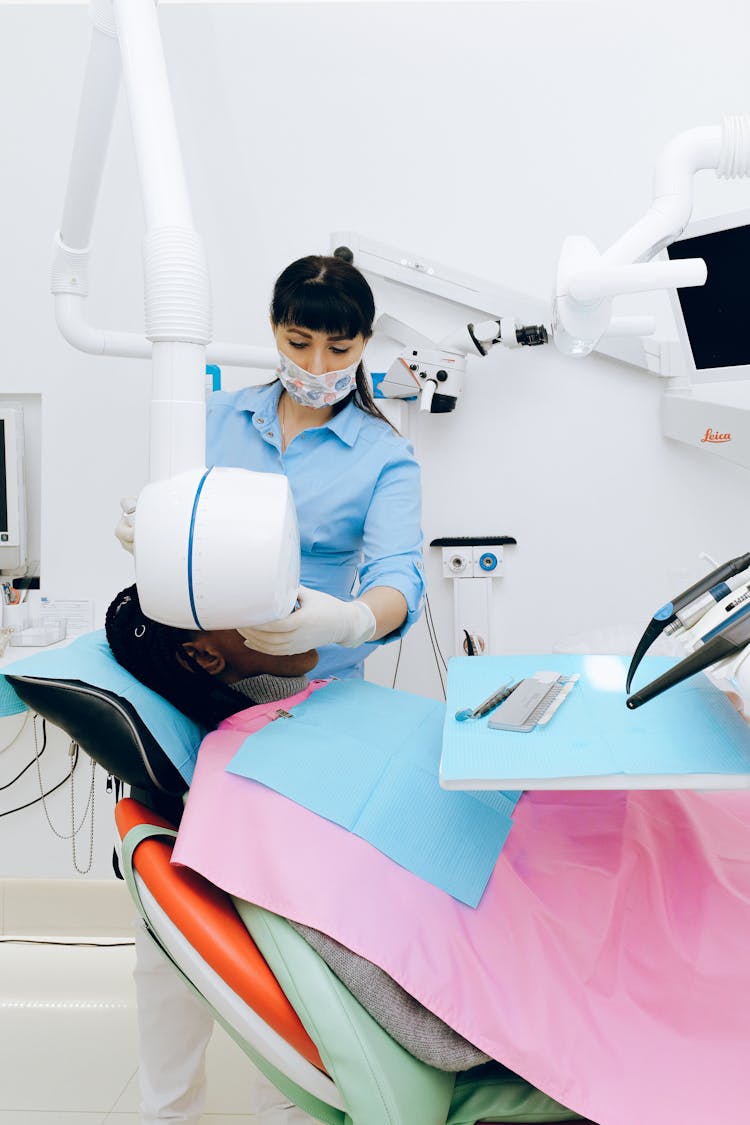 Female Dentist Working In Modern Office With Patient