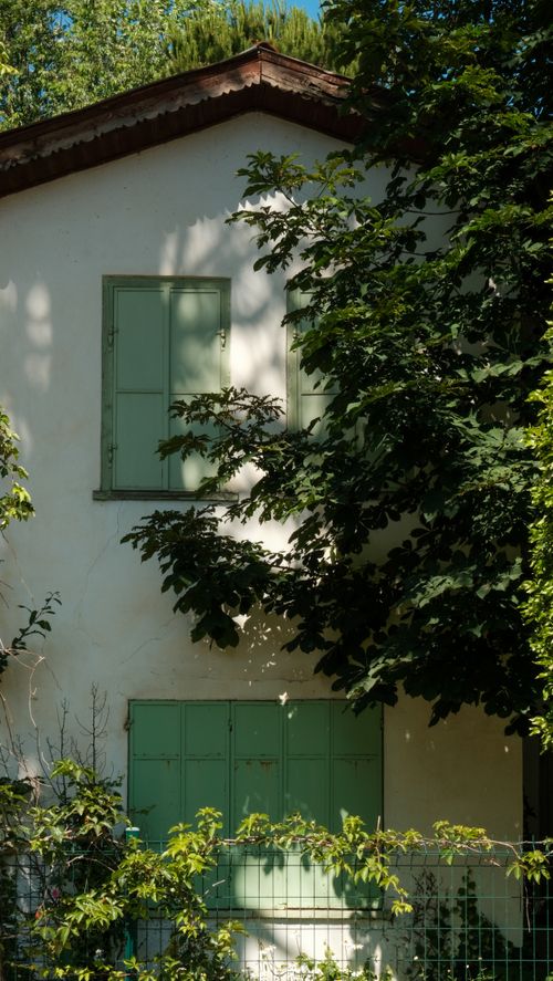 Free Charming house in Ödemiş, Türkiye with shutters and lush greenery casting shadows. Stock Photo
