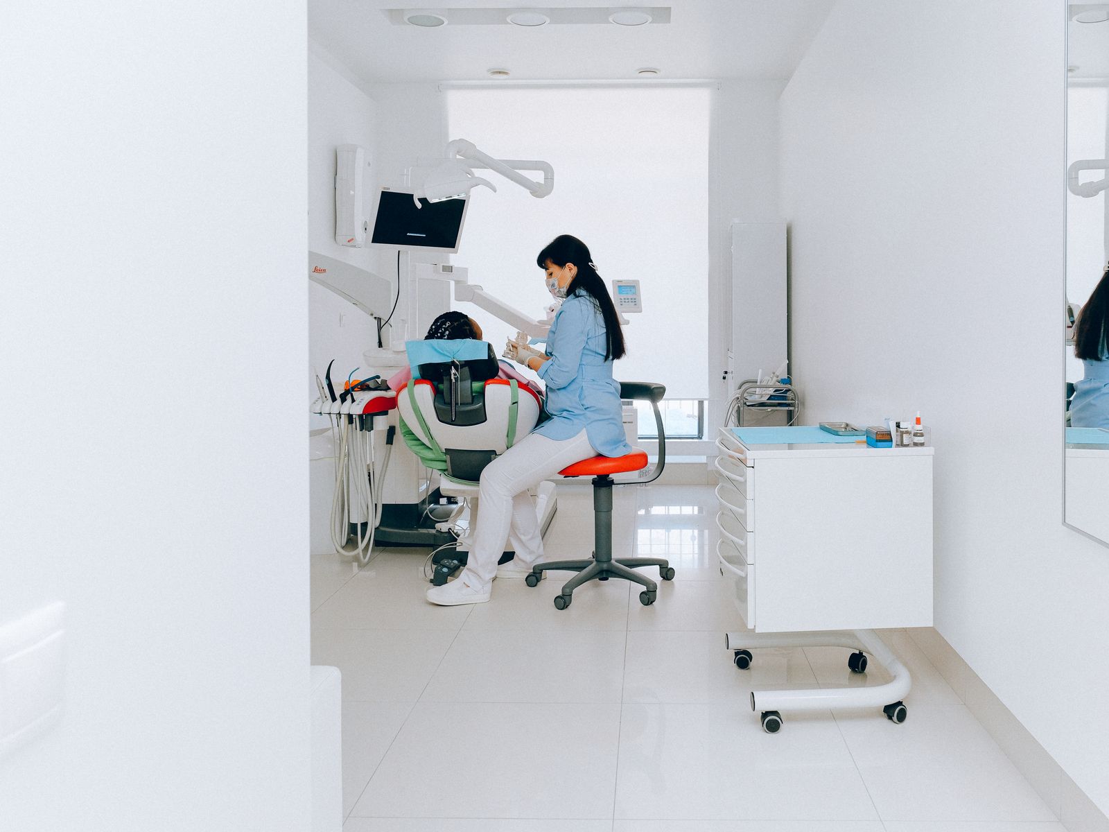 Smiling dental patient and clinician in a bright modern private dental clinic