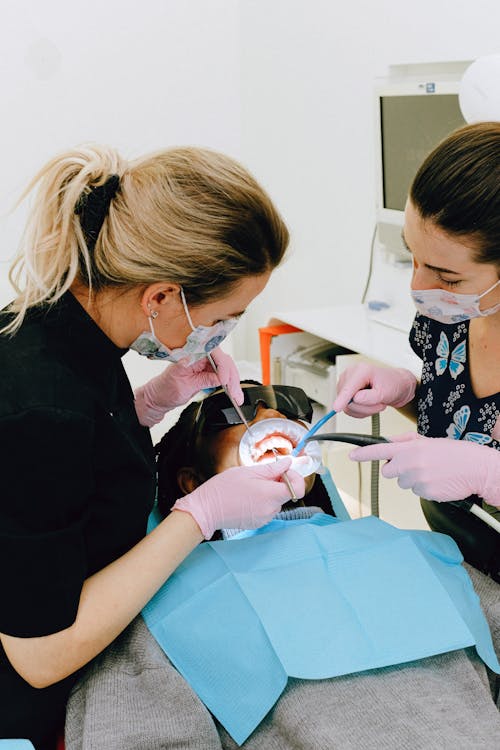 Femme Dentiste Avec Assistant Traitant Les Dents Du Patient En Clinique