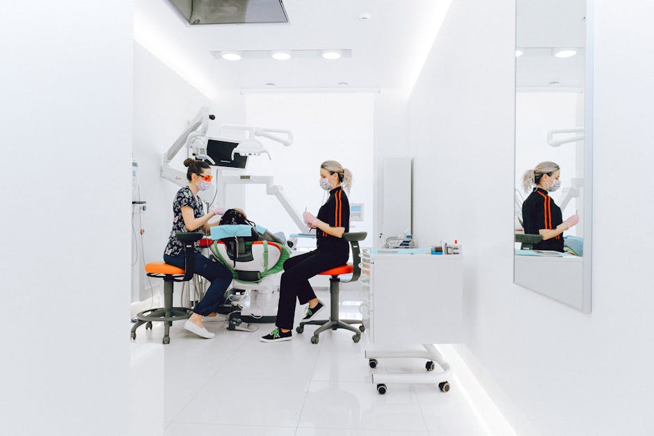 Female dentist and assistant examining patients teeth in clinic