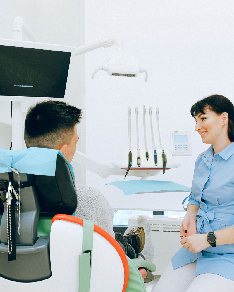 A relaxed young patient chatting with a dentist before a filling