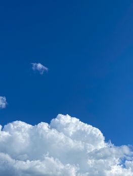 Cumulus clouds against a vivid blue sky, showcasing a serene and peaceful atmosphere.