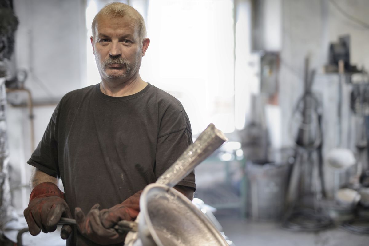 Professionnel expérimenté au travail dans son atelier, dont le savoir-faire peut être validé par une VAE