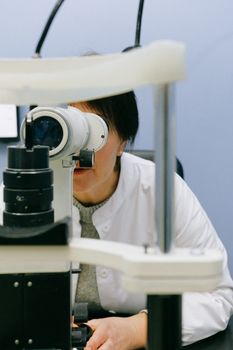 一名女科学家在实验室里通过显微镜聚焦，分析样本