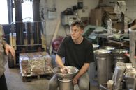 在繁忙的工业车间里，专注的男性工人正从事金属加工