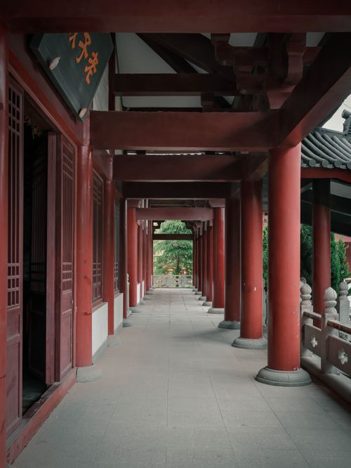Free A serene view of traditional Asian architecture featuring red columns and tiled roof in a corridor. Stock Photo