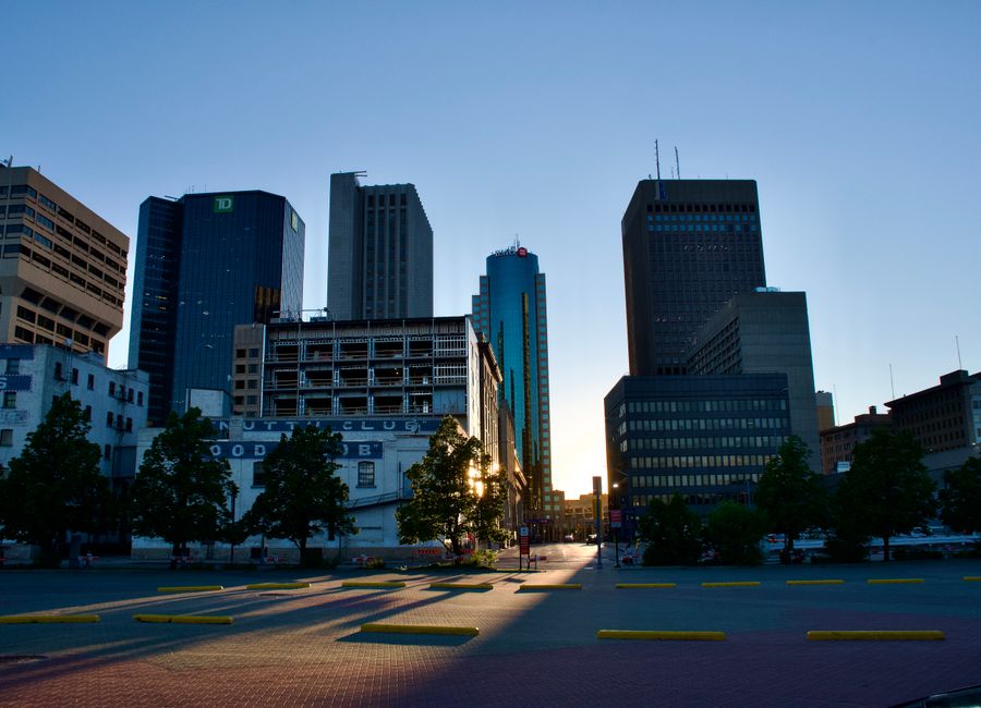 Stunning cityscape view of downtown Winnipeg, Manitoba, Canada during sunset with modern skyscrapers silhouetted.