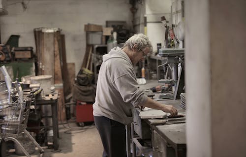 Maestro Senior De Cabello Blanco En El Manejo De Detalle Workbench