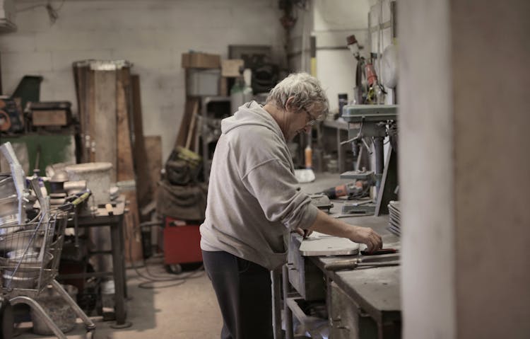 Senior White Hair Master Handling Detail On Workbench