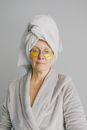 Senior woman with eye patches and eyeglasses after shower