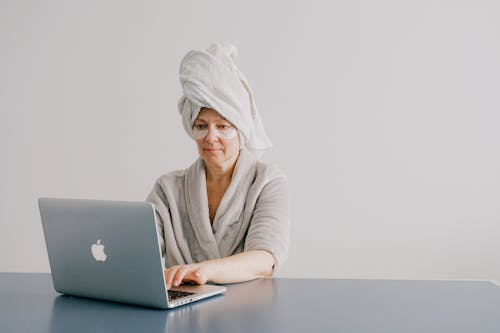 Woman With Towel On Her Head While Using A Laptop