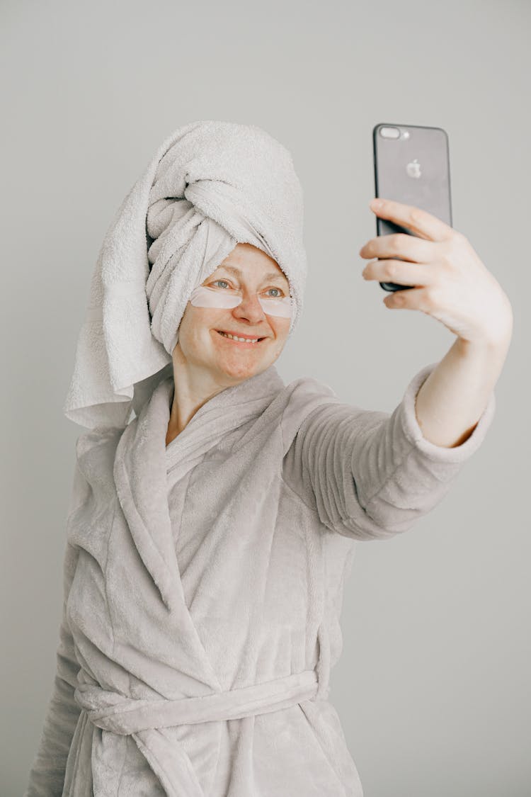 Woman In Gray Bathrobe Holding Iphone