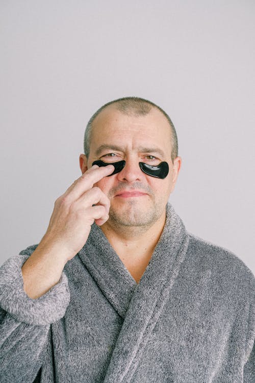 Man in Gray Bathrobe Wearing Black Eye Mask