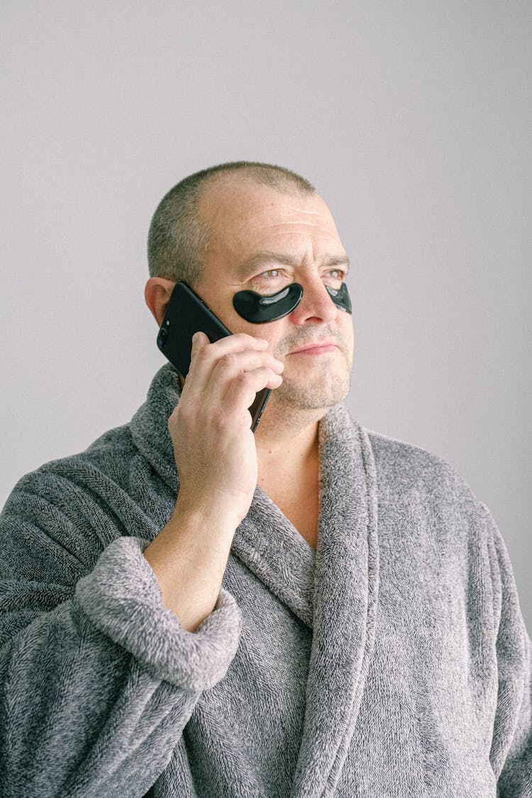 Man In Gray Bathrobe Wearing Black Eye Mask