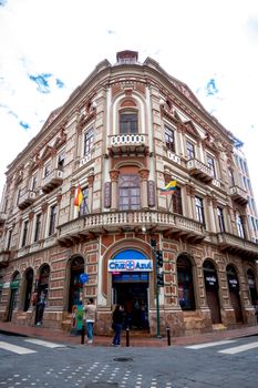 Ornate historic building with flags in Cuenca, Ecuador, showcasing beautiful architecture.