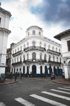 Detailed street view of a historic building in Cuenca, Ecuador under a dramatic sky.