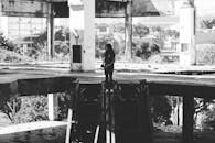 这张黑白照片里，一个孤独的人站在废弃的城市建筑中