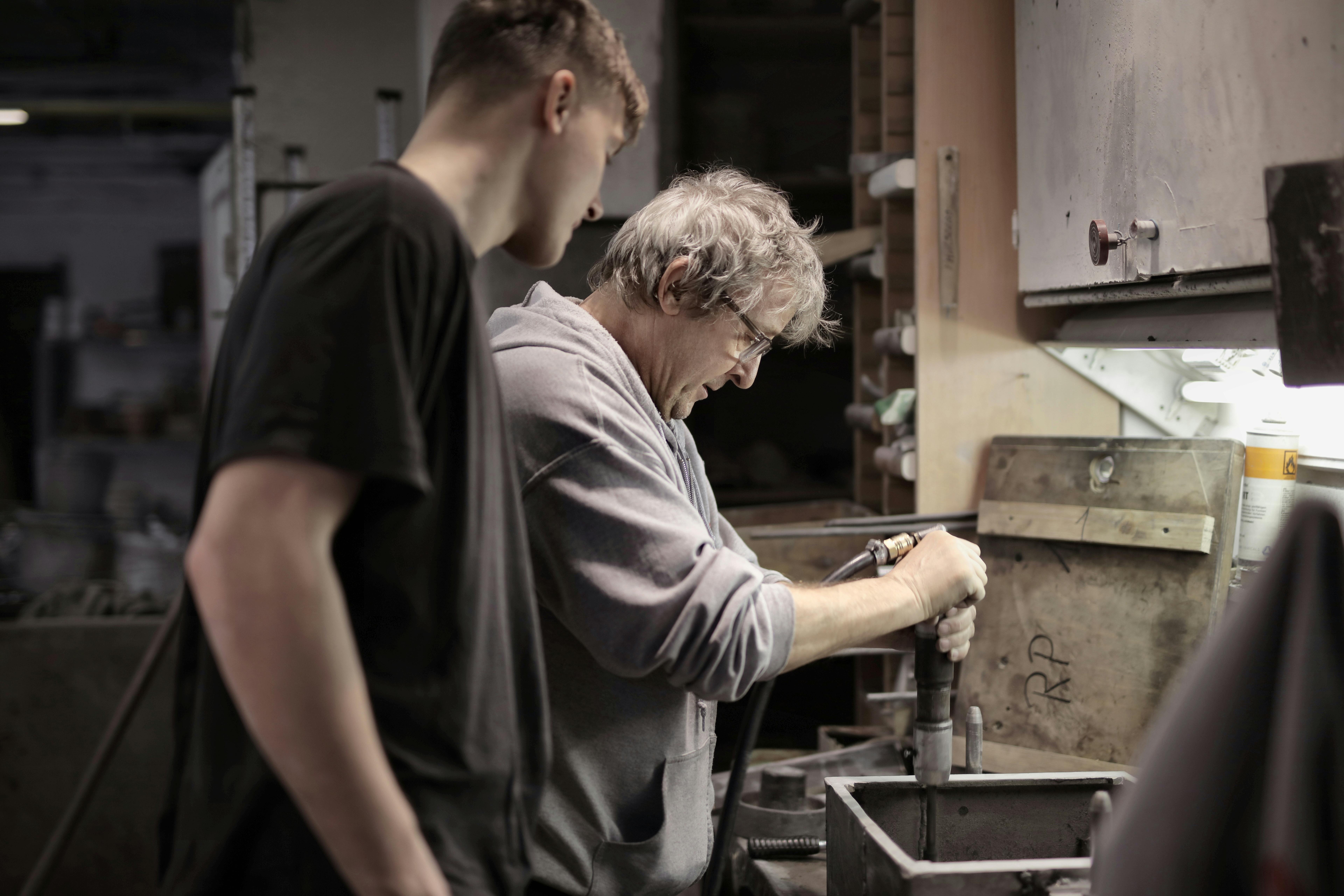 foreman teaching apprentice working with tools