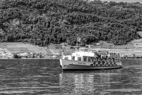 Free Ferry named Stadt Biel cruising on Lake Biel with vineyard hills in the background. Stock Photo