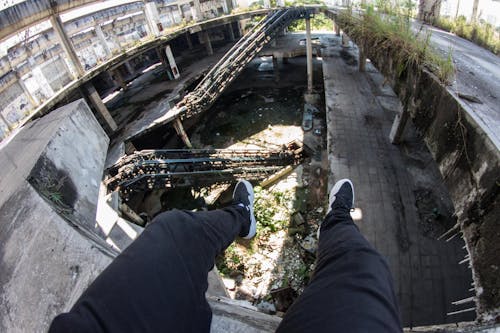 Person Sitting on Gray Concrete Ledge