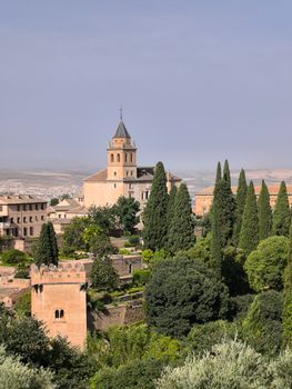 Beautiful landscape of Alhambra gardens with iconic architecture under clear sky.