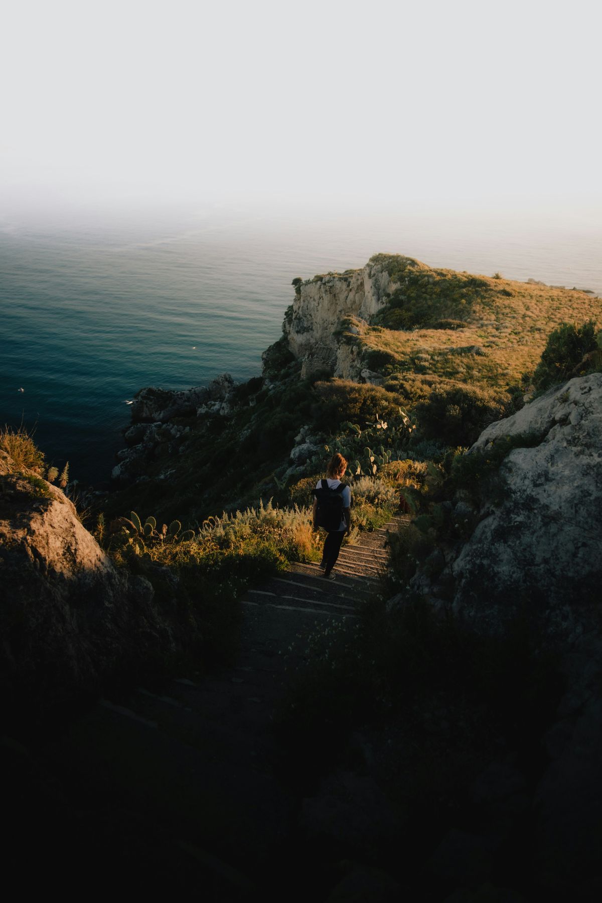 Traveller on a sunlit coastal path — photo by Daniel J. Schwarz on Pexels