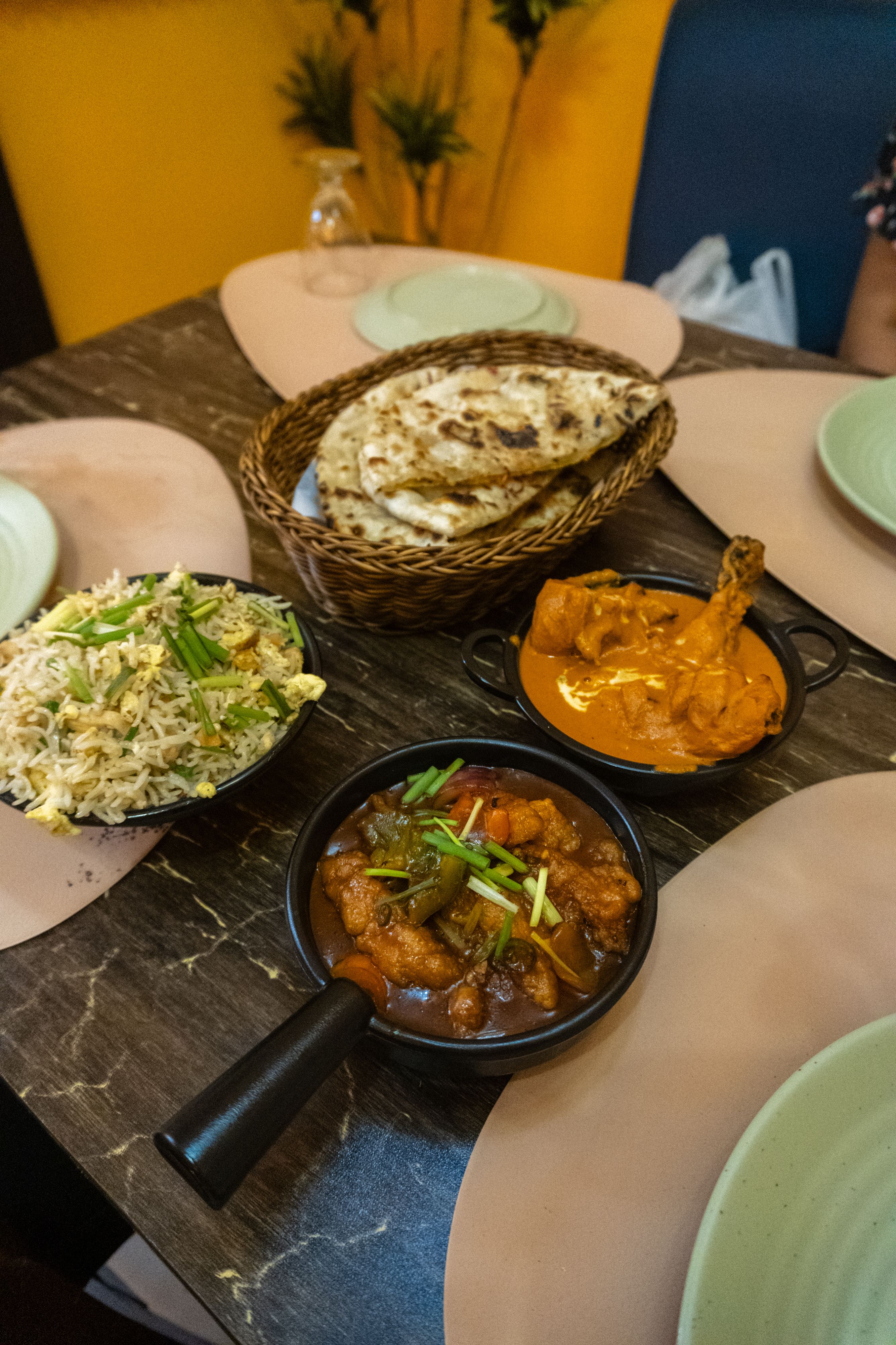 Delectable Indian curry dishes served with naan bread on a wooden table, perfect for a hearty meal.
