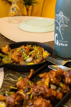 Savor a spicy chicken dish garnished with vegetables, perfect for culinary enthusiasts.